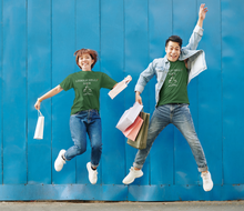 Load image into Gallery viewer, Female and male jumping wearing forest green Jingle Bell Rock t-shirts